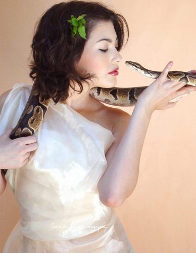 Woman and snake looking into each other's eyes
